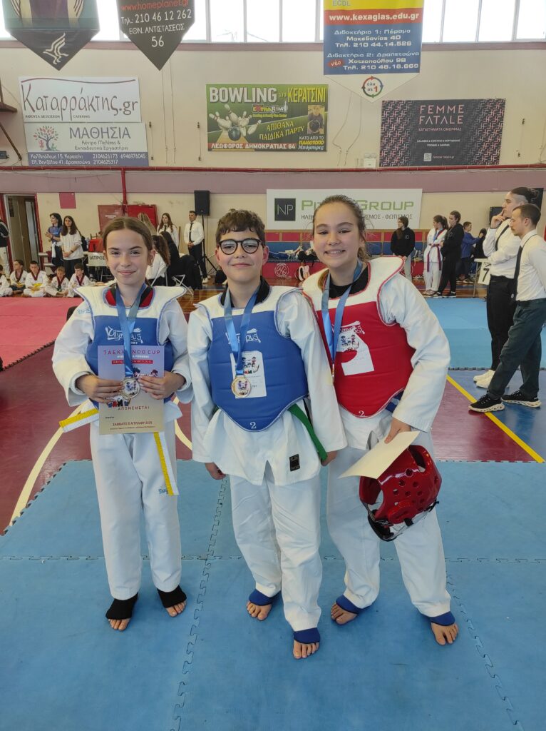 Taekwondo Athens –αθλητές ποζάρουν με κύπελλο και μετάλλιο μετά από αγώνες