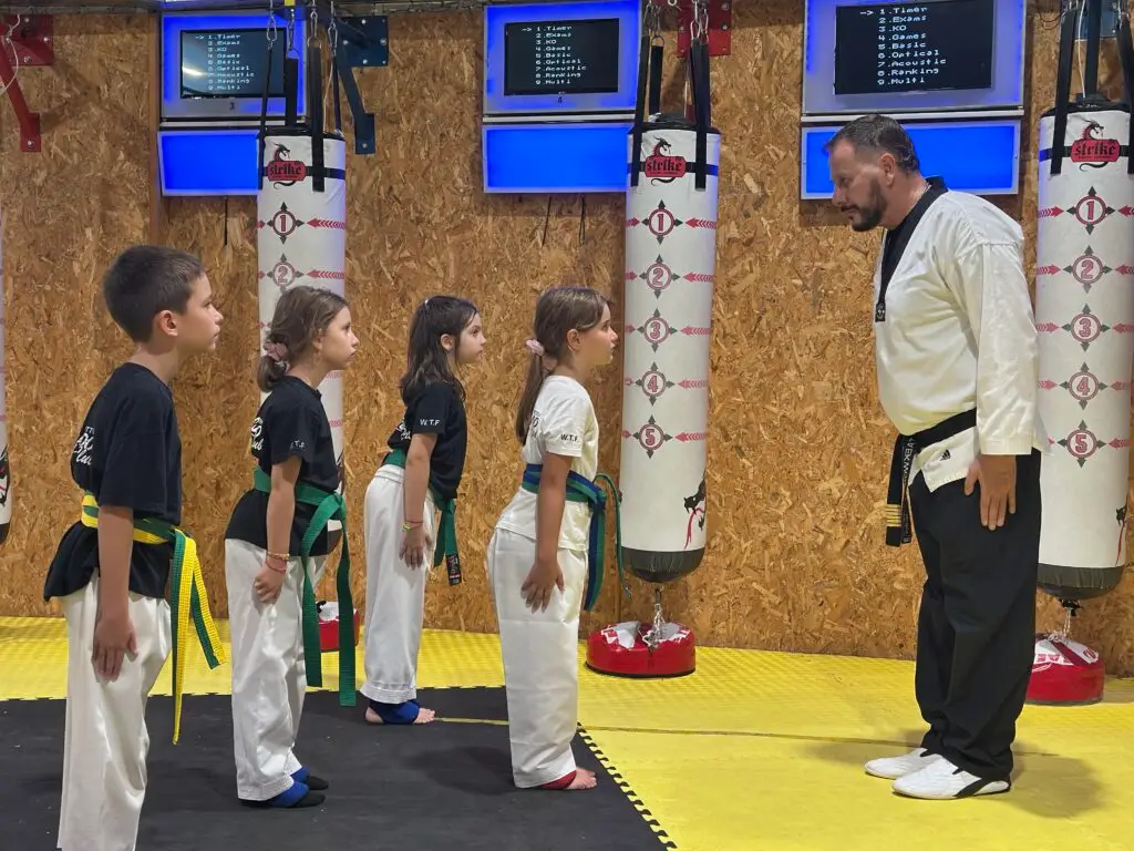 Βασίλης Τασιόπουλος με μικρούς αθλητές Taekwondo σε στάση σεβασμού και πειθαρχίας